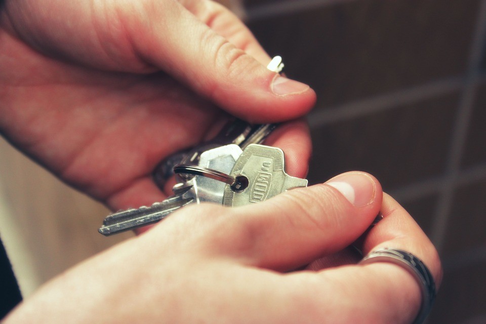 Mains tenant un trousseau de clés de logement