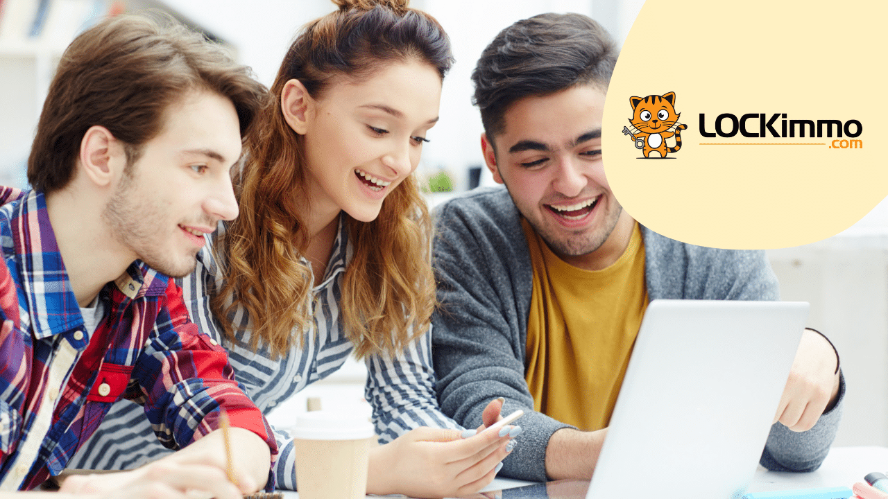 Trois jeunes gens souriants devant un ordinateur portable