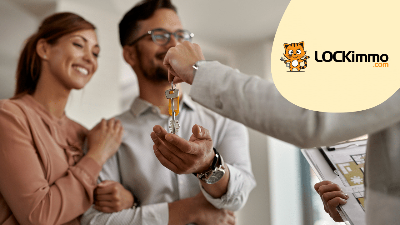 Remise de clés à un couple souriant devant un plan de logement