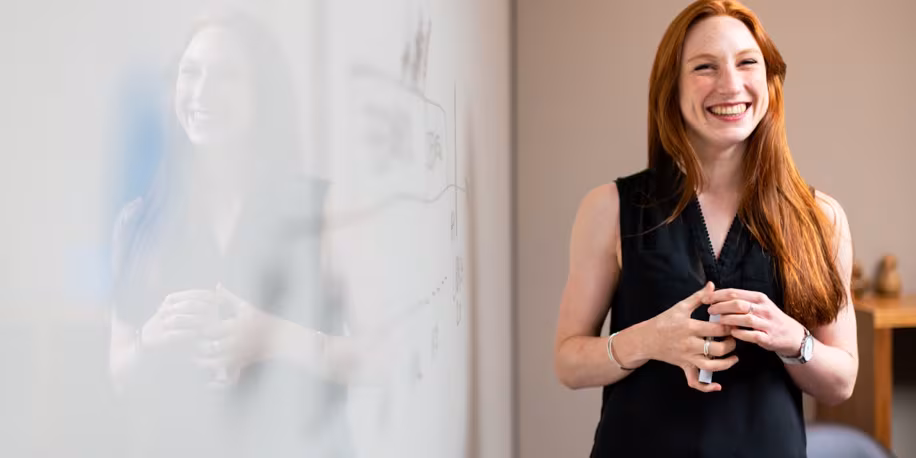 Collaboratrice d'un cabinet de gestion locative devant un tableau blanc
