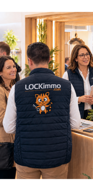 Équipe LOCKimmo en gilet floqué accueillant des visiteurs sur un salon