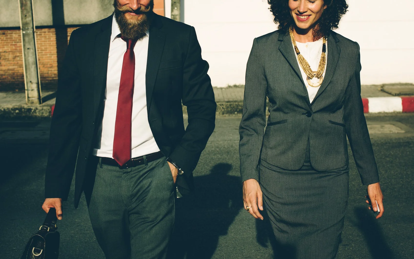 Deux professionnels de l’immobilier en costume marchant côte à côte
